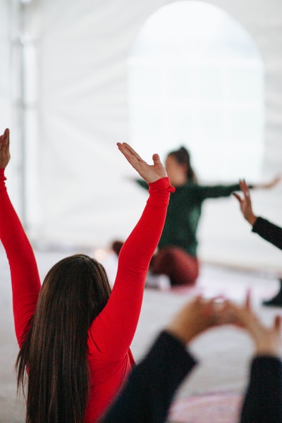 woman in red long sleeve shirt raising her hands